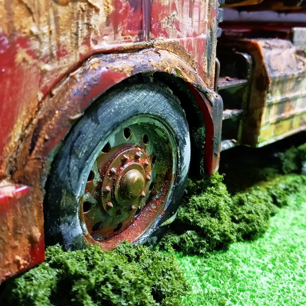 applying colored sponge mixture on base of the abandoned truck